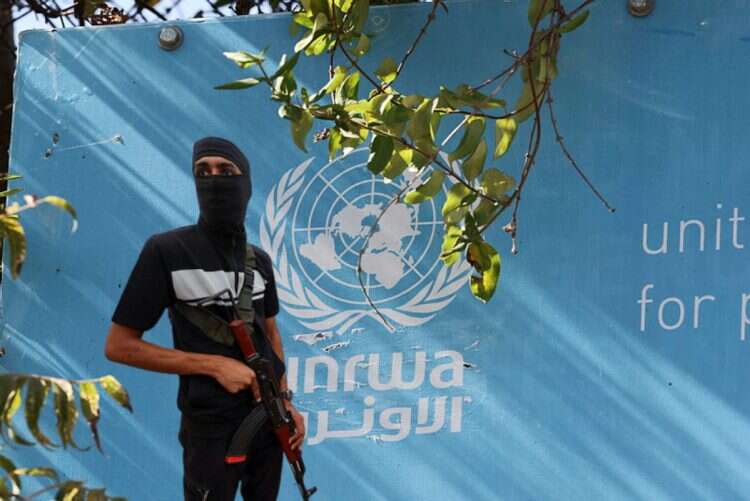 A Hamas terrorists against the backdrop of an UNRWA building (reproduction)