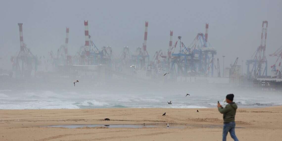 A person walks on an empty beach during stormy weather in Ashdod, Israel, 10 December 2025 Winter storm update: Heavy rain, flood warnings, and road closures