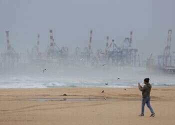 A person walks on an empty beach during stormy weather in Ashdod, Israel, 10 December 2025 Storm Byron claims first victim as temperature plunges