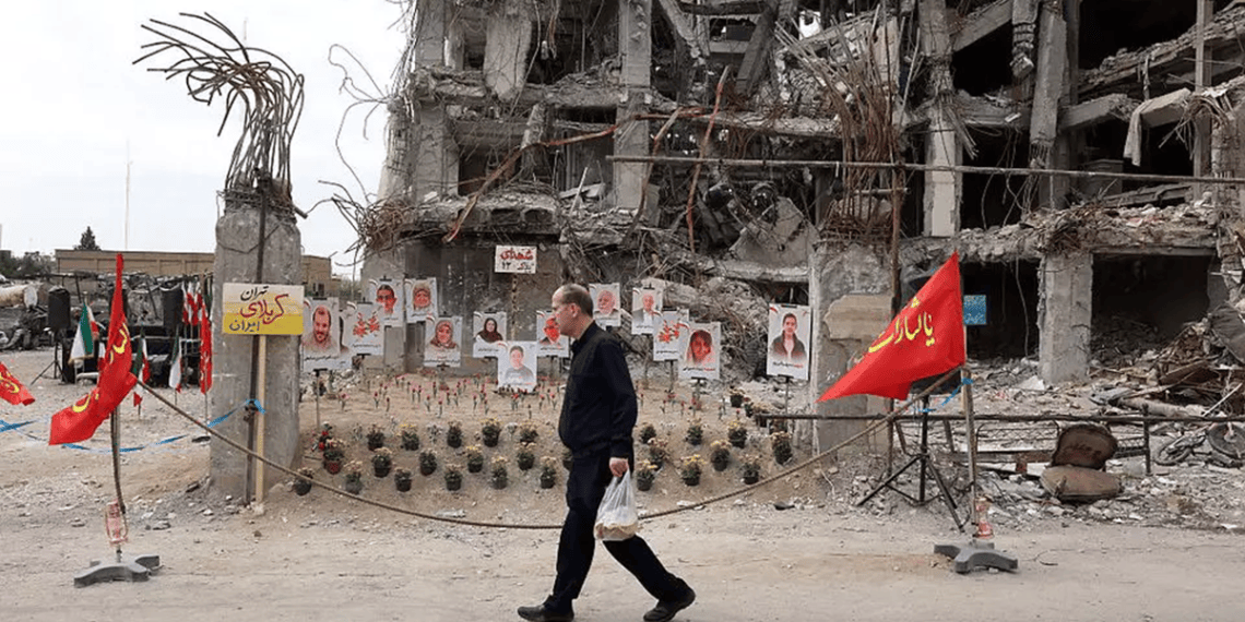 A Tehran resident walks past a war-damaged building Iran's central bank warned the regime of economic collapse