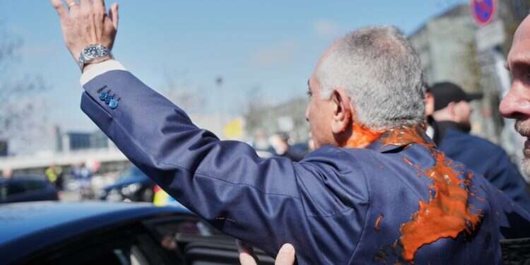 Activist douses Iranian crown prince in red paint at Berlin conference