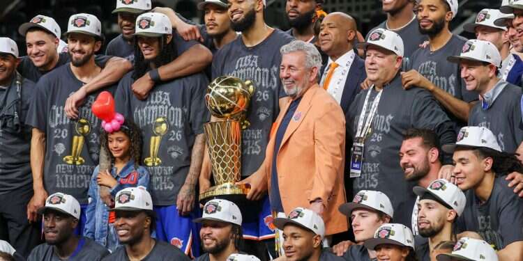 New York Knicks owner James Dolan and the Knicks pose with the trophy after the Knicks defeat the San Antonio Spurs during game five of the 2026 NBA Finals at Frost Bank Center New York Knicks capture historic NBA championship, ending 53-year title drought