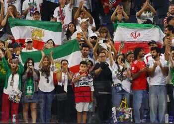 The two Iranian flags in the stands. Photo: Reuters After boos during Iran's anthem, regime supporters and opponents find common ground