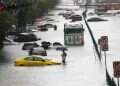 People wade through floodwater as submerged vehicles are abandoned during a downpour on a flooded major street, Phetchaburi Road in Bangkok, Thailand, 26 September 2026 Unprecedented floods submerge Bangkok forcing mass evacuations