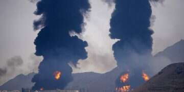 Plumes of smoke and fire rise after debris from an intercepted Iranian drone struck an oil facility, according to authorities, in Fujairah, United Arab Emirates, Saturday, March 14, 2026 Crude markets roiled by regional conflict as oil touches $100