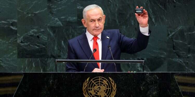 Prime Minister Benjamin Netanyahu holds up a pager as he addresses the 81st United Nations General Assembly at UN headquarters in New York City, US, September 24, 2026. Israeli banned from hackathon over concerns pagers may 'explode in participants' faces'