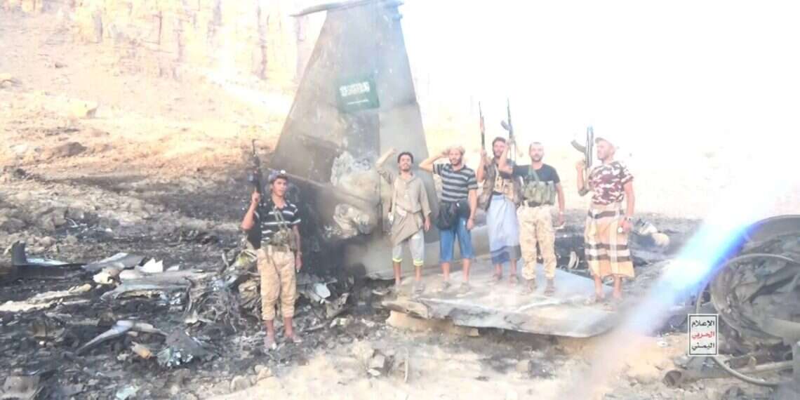 Houthi operatives stand on what the terrorist group claims are remains of a Saudi F-15 Houthis claim downing of Saudi F-15, release video of burning wreckage