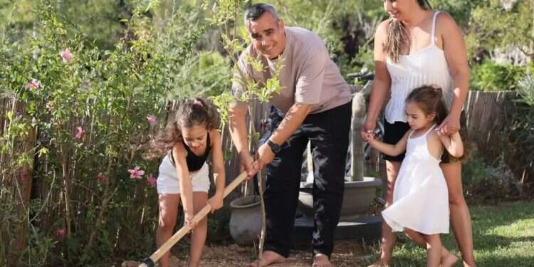 Omri Miran and Lishay Miran-Lavi plant a pomegranate tree with their daughters in the yard of their home in Carmit | Photo: Yehonatan Shaul 'Now I'm living': Omri Miran rebuilds life after Hamas captivity
