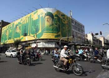Iranians drive past a billboard carrying a picture of late Iranian Supreme Leader Ayatollah Ali Khamenei (C) and Hamas leaders on a street in Tehran, Iran, 6 October 2026 Iran to answer US proposal within days amid renewed war planning