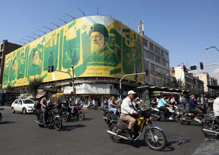 Iranians drive past a billboard carrying a picture of late Iranian Supreme Leader Ayatollah Ali Khamenei (C) and Hamas leaders on a street in Tehran, Iran, 6 October 2026