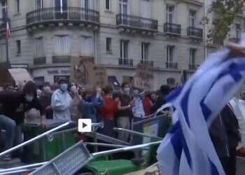 A man lunges toward a woman holding an Israeli flag at the Science Po protest in Paris on Oct. 7, 2026 WATCH: Paris students can't handle sight of Israeli flag